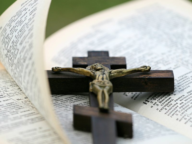 Cross on top of an open Bible.
